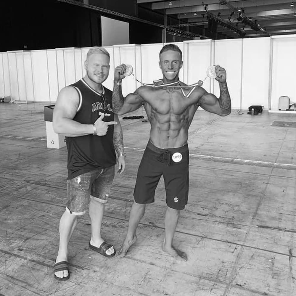 Coach and client celebrating with medals backstage